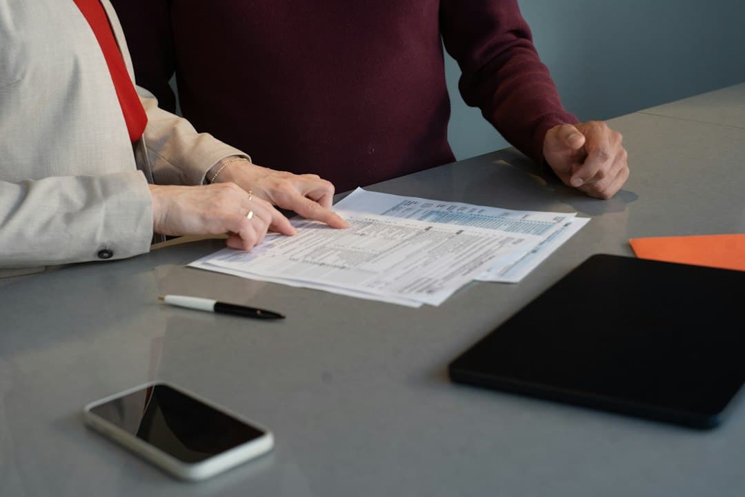 Two professionals reviewing paperwork at a conference table